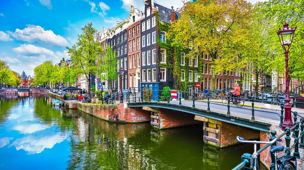 Bridge over channel in Amsterdam Netherlands houses river Amstel landmark old european city spring